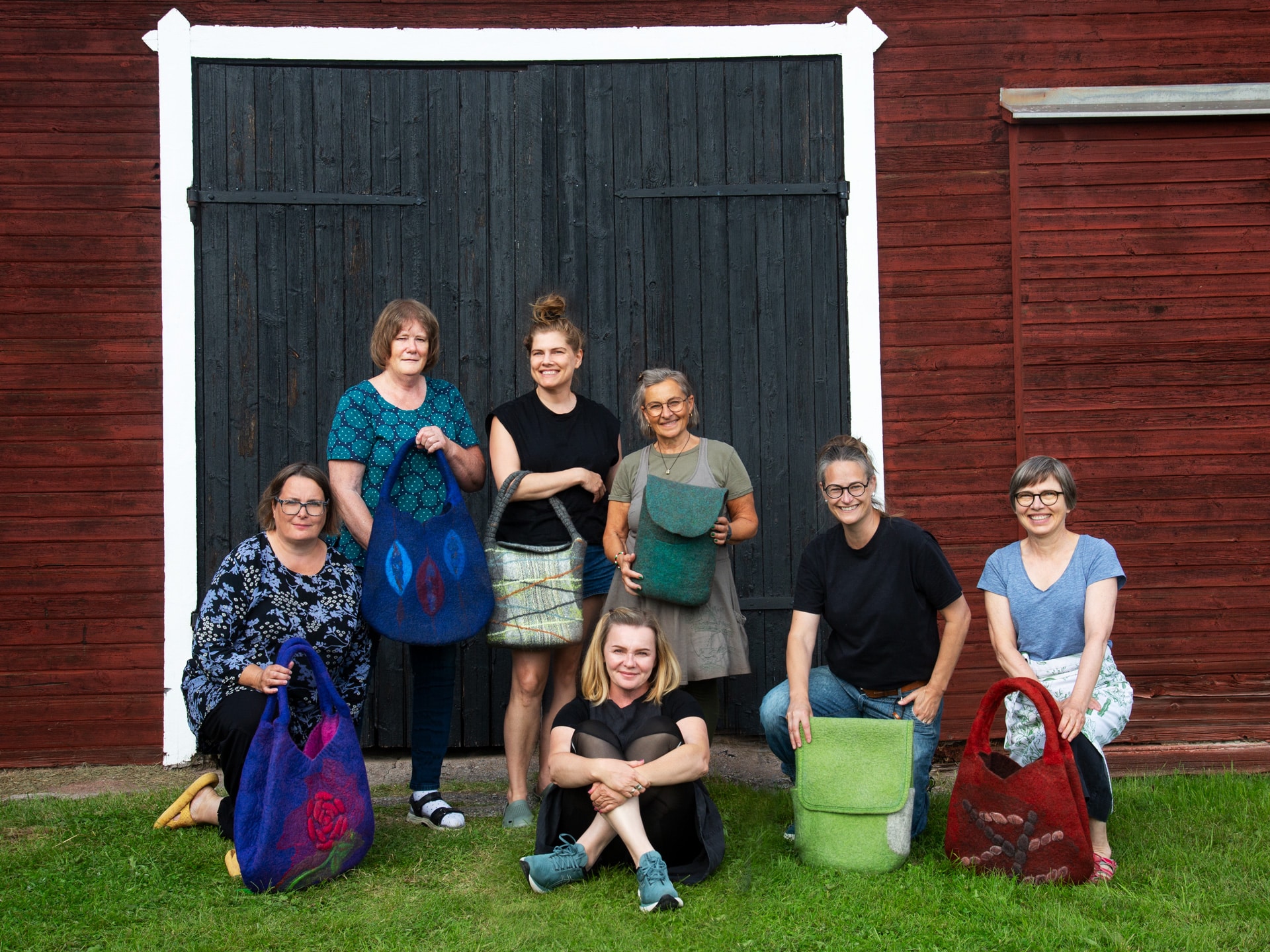 Group picture with participant posing happily with their bags from the workshop.