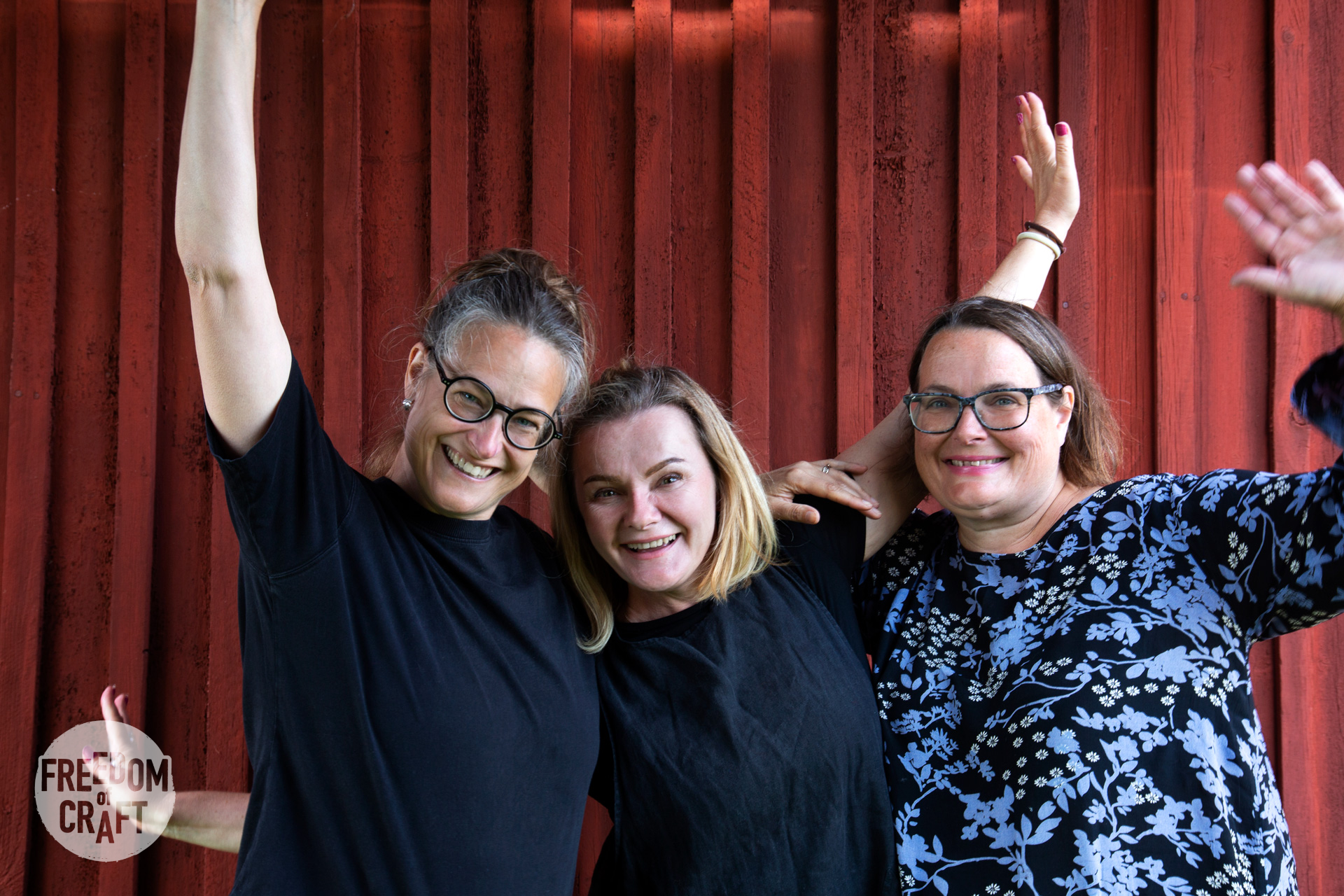 Moa, Natalya and Anna smiling and rising their hands in a happy welcome.